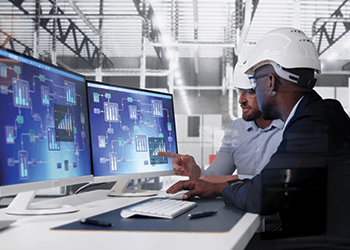 Two technicians reviewing control dashboards