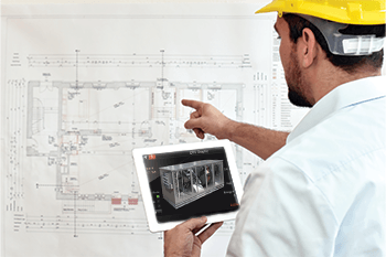 Technician comparing system drawing to model on tablet